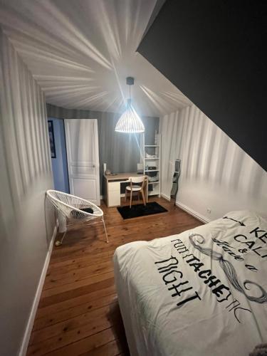 a bedroom with a bed and a desk and a light at Maison 5mn du centre ville du Mans à pied in Le Mans