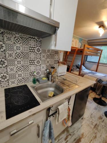une cuisine avec un évier et une chambre avec un lit dans l'établissement Studio à Super Besse 800m des pistes, à Besse-et-Saint-Anastaise