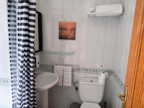 małą łazienkę z toaletą i umywalką w obiekcie Hostal Betelu w mieście Betelu
