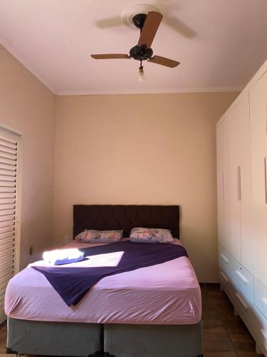 a bedroom with a bed with a ceiling fan at Casa tropical in Pirassununga