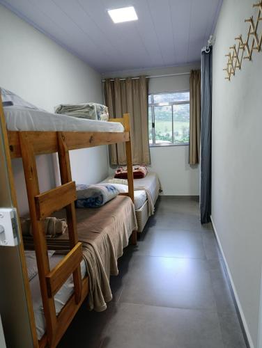 a room with two bunk beds and a window at Kitnet Sol e Lua in Caparaó Velho