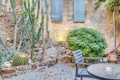 a table and chair next to a wall with cactus at Sofia's Lovely Rooms in Khóra Sfakíon