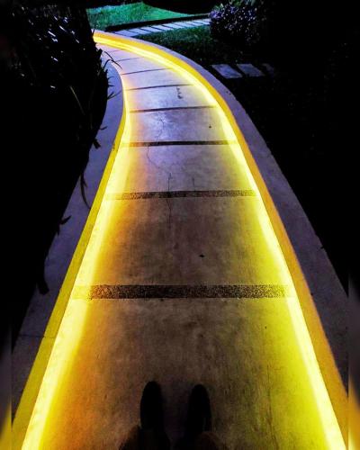 a person standing on a sidewalk at night at Cozy 1BR with City View, Beach Access and Wave Pool in Manila