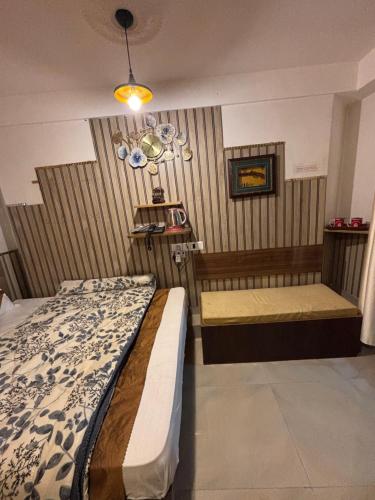 a bedroom with a bed and a bench in it at Hills Royal Residency in Jālāpahār