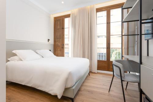 a bedroom with a bed and a desk and a window at Art Experience B&B "Hotel Boutique" in Vinaròs