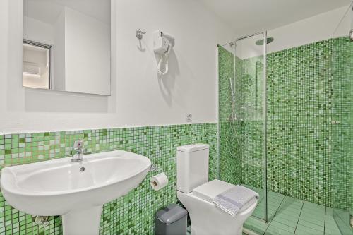 a bathroom with a sink and a toilet and a shower at Sofia's Lovely Rooms in Khóra Sfakíon