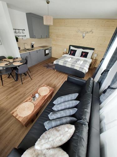 a living room with a couch and a bed at My Deer Apartment in Deštné v Orlických horách