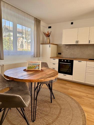 a living room with a table and a kitchen at Ferienanlage Villa Maare in Gillenfeld
