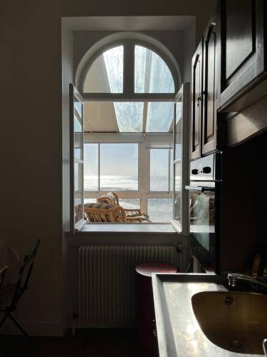 Un baño con una gran ventana y un lavabo. en La Colombière - Appartement Villa front de mer, en Granville