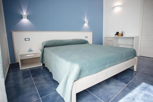 a bedroom with a large bed with a green blanket at Nel blu dipinto di blu in Pianillo
