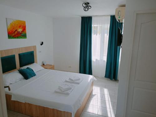 a bedroom with a large white bed with green curtains at Pam Dubova Holiday in Dubova