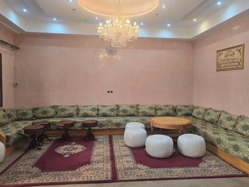 a living room with a couch and tables and a chandelier at Beautiful Villa on 3 ha farm in Marrakech