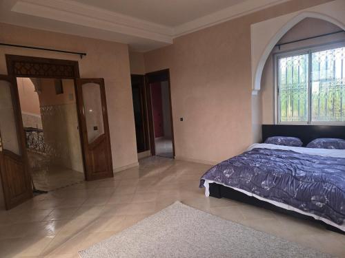 a bedroom with a bed and a large window at Beautiful Villa on 3 ha farm in Marrakech