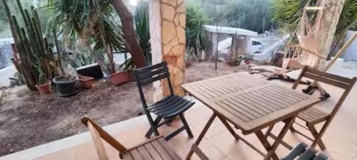 クアルトゥ・サンテーレナにあるPorzione di villetta a Capitanaの木製テーブル、椅子2脚、テーブル1台、椅子1脚