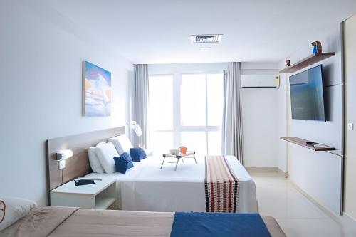 a hotel room with a bed and a tv at Paraíso beira-mar em Tambaú! Nobile Suites #508 in João Pessoa