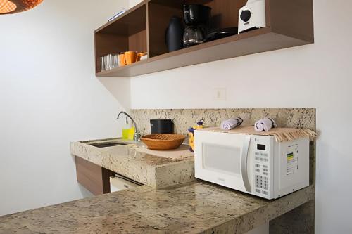 a kitchen with a white microwave on a counter at Paraíso beira-mar em Tambaú! Nobile Suites #508 in João Pessoa