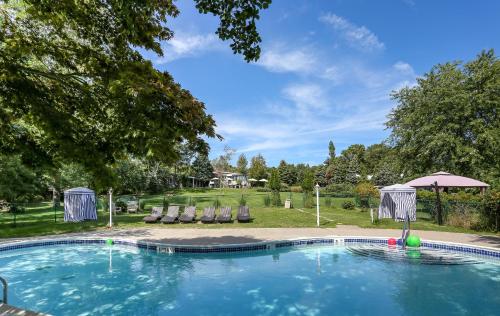 a swimming pool with chairs and an umbrella at Hamlet Inn in Southampton