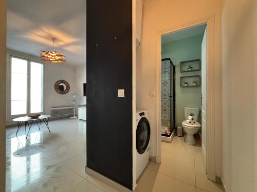 une salle de bain avec une machine à laver au milieu d'une pièce dans l'établissement Studio 2 Libération proche tram, à Nice
