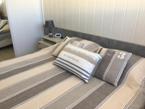 - un lit avec des oreillers dans l'établissement Les Anthemis- Bord de mer, à Saint-Raphaël