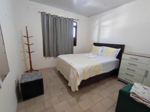 a bedroom with a bed and a dresser in it at Apê Aconchego in Vitória da Conquista