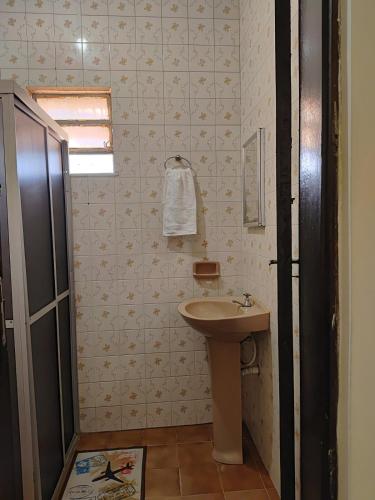 a small bathroom with a sink and a mirror at Apê Aconchego in Vitória da Conquista