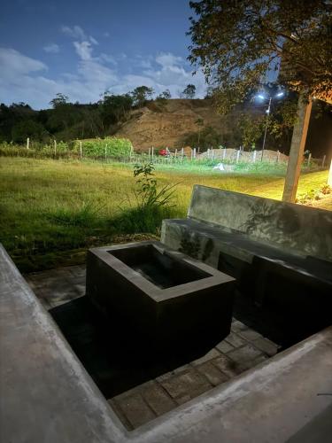a concrete bench in a park with a field at Cabañas La Sanguina, Loft H1 in Ocaña