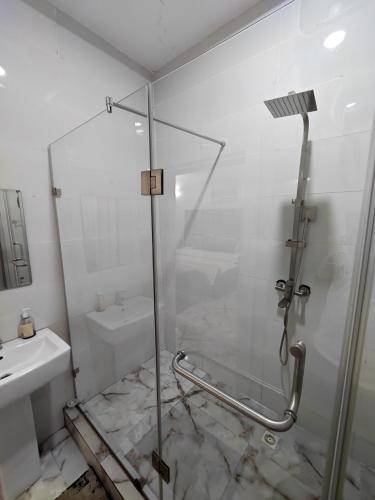 a bathroom with a shower and a sink at Lekki Conservational Apartment - 24hrs Power, Wifi, Smart TV, Netflix, Nature View in Lekki