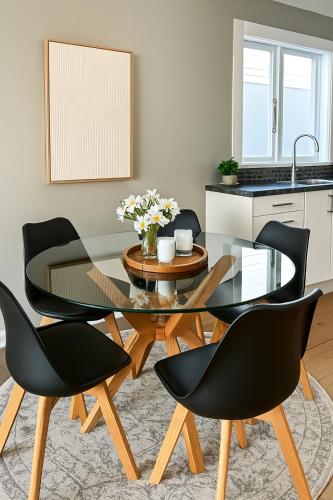 a dining room with a glass table and chairs at Skyline City - Entire Character Apartment - Views, Parking and Netflix in Wellington