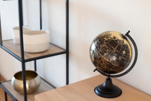 a globe on a table next to a shelf at STAYY On Top Penthouse-Apartment near Airport in Opfikon