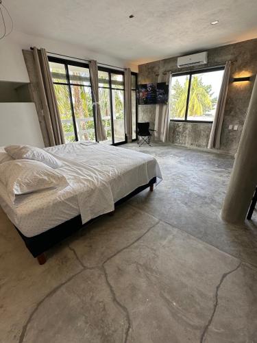 a bedroom with a large bed and large windows at Very quiet in Isla Mujeres