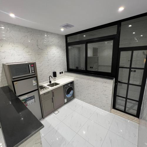 a small kitchen with a sink and a microwave at Bee House in Taif