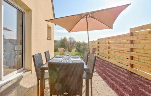 a table with an umbrella on a patio at 2 Bedroom Stunning Home In Créances in Créances