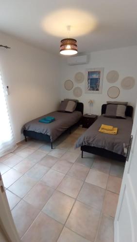- une chambre avec 2 lits et du carrelage dans l'établissement Bas de Villa 