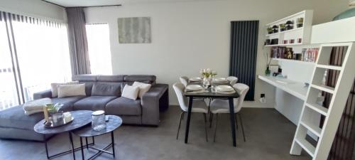 ブレーデネにあるApartment Sea heated Pool with Parking - Promenade Cannes Bredeneのソファとテーブルのあるリビングルーム