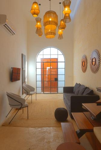 a living room with a couch and a large window at Casa de las Puertas in Mérida