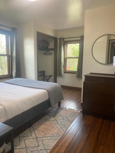 a bedroom with a bed and a dresser and a mirror at Muttley's Cottage in Independence