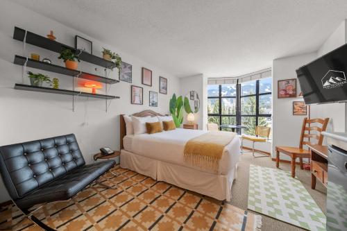 a bedroom with a bed and a couch and a television at Mid Century Modern - Studio w Pool & Hot Tub in Whistler