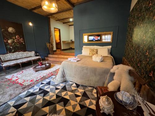 IúnaにあるChalés da Toscanaの部屋にベッドとソファがある寝室