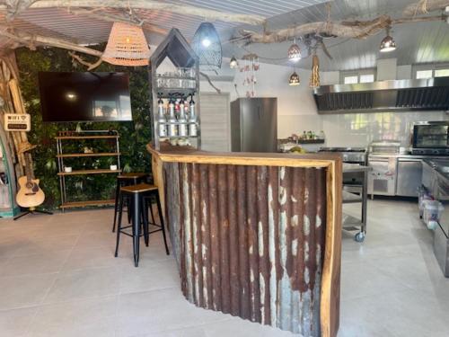 a kitchen with a bar in the middle of a room at Relais Fenua in Punaauia