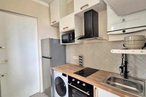 une petite cuisine avec un évier et un réfrigérateur dans l'établissement Charmant appartement T2, à Toulon