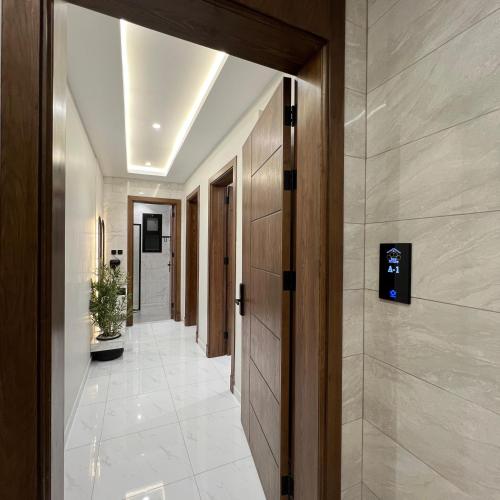 a hallway in a building with a door and a tile floor at Bee House in Taif