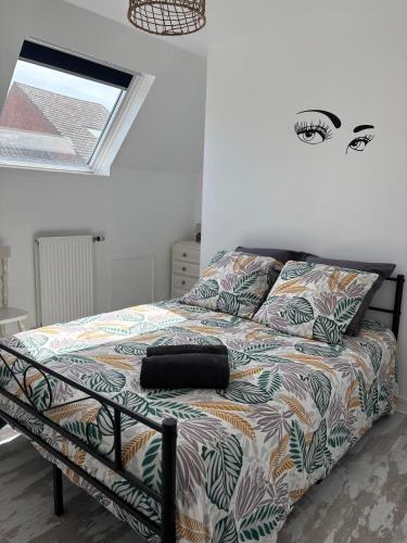 une chambre avec un lit avec une couette colorée dans l'établissement Chez Valentine, à Grand-Fort-Philippe