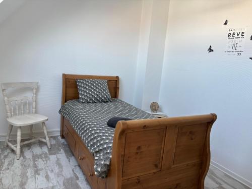 ein kleines Schlafzimmer mit einem Bett und einem Stuhl in der Unterkunft Chez Valentine in Grand-Fort-Philippe