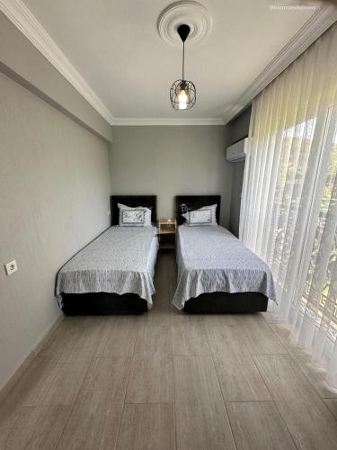 a bedroom with two beds and a large window at Villa BB Mugla 1 in Ortaca