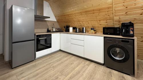 a kitchen with a washing machine and a washer at Cabana Luminis in Râşnov