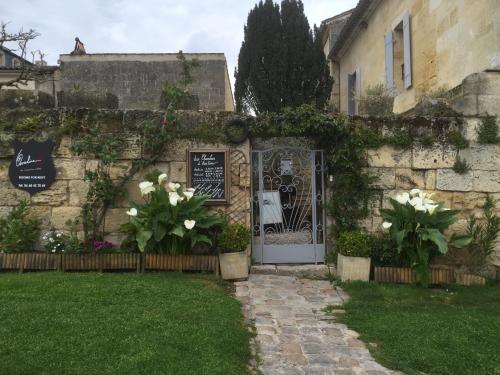 an entrance to a house with a gate and flowers at Les Chambres d'Ovaline in Saint-Émilion