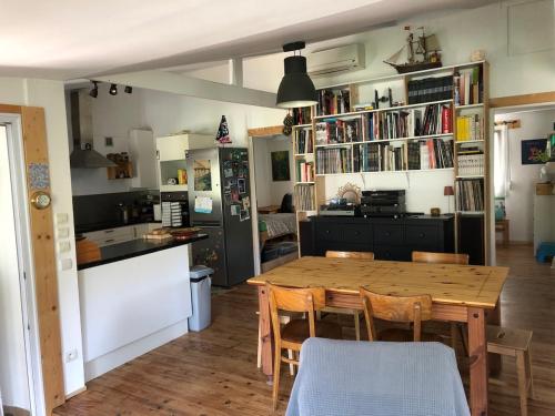 une cuisine et une salle à manger avec une table et des chaises en bois dans l'établissement Maison familiale sur la Presqu'île de Giens, à Hyères