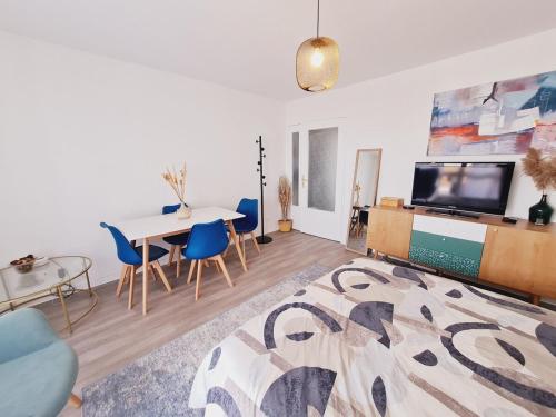 un salon avec une table et une télévision dans l'établissement Appartement entier proche du Parc de la Tête d 'Or, à Villeurbanne