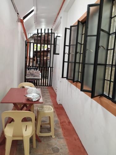 a table and chairs in a room with windows at LR Bungalow in Tacloban