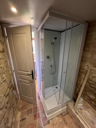 une douche avec une porte vitrée dans une salle de bain dans l'établissement La Bergerie- Beautiful barn conversion in Chinon, Loire Valley, à Chinon